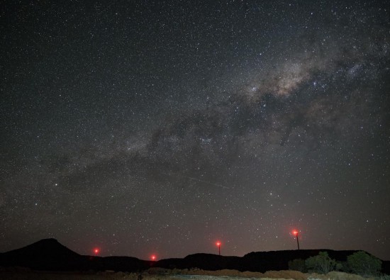 2025年10月22日，在南非北开普省德阿镇，德阿风电项目的风机在星空下运转。新华社记者韩旭摄